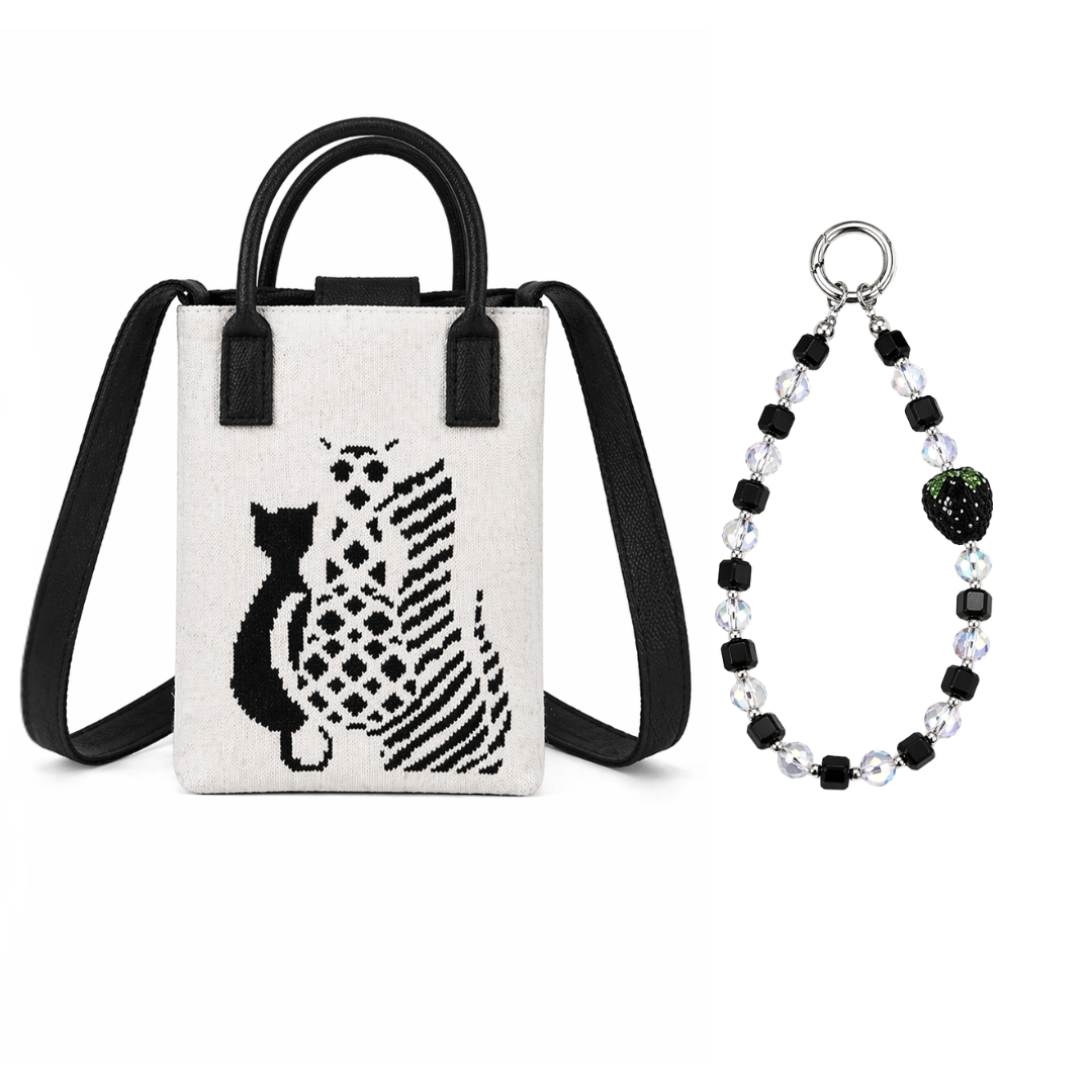 Small white bag with black cat design and black strap, next to a black and white beaded bracelet on a white background